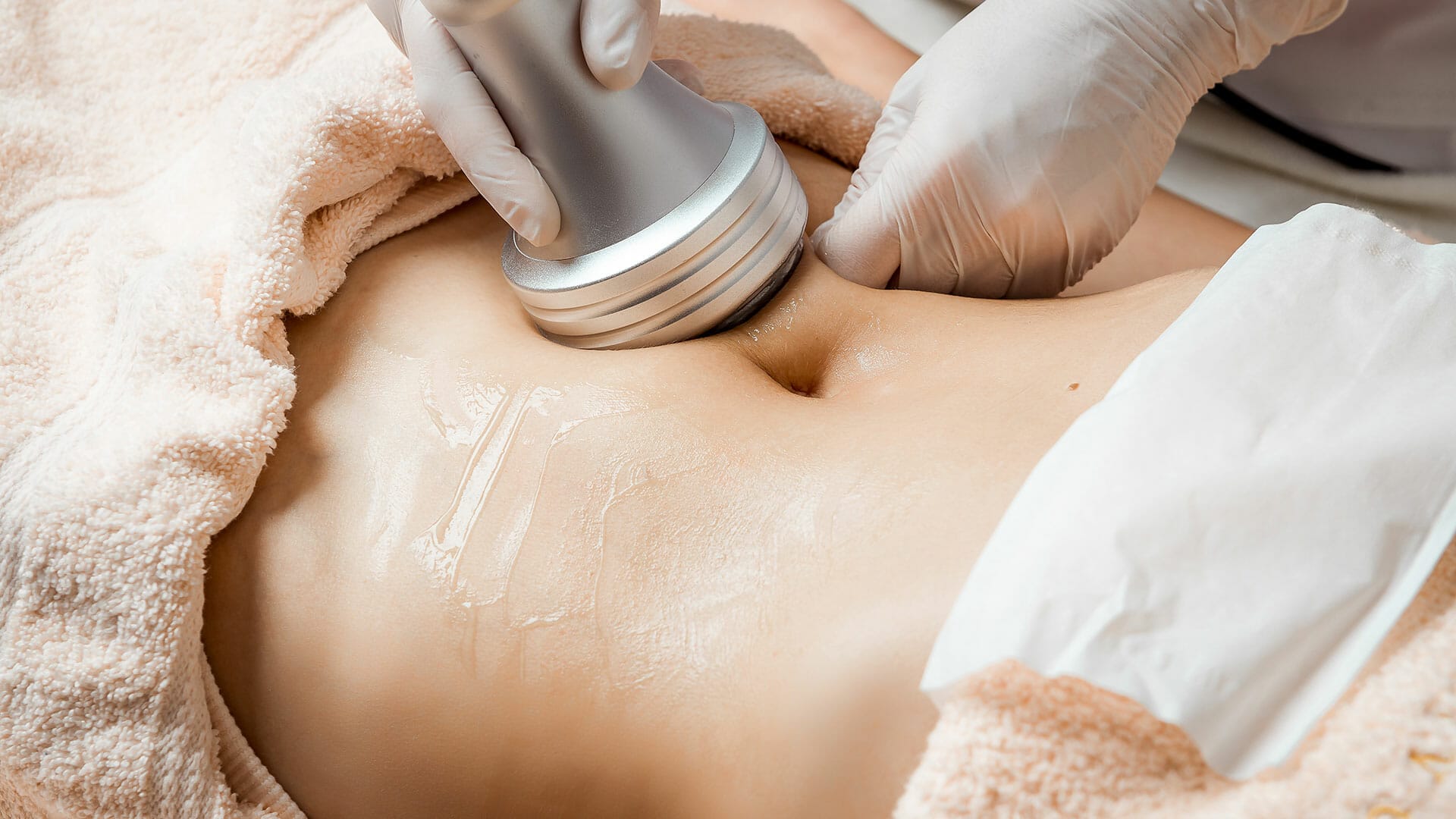 A woman getting non-invasive body sculpting treatment in a laser skin and hair care center.